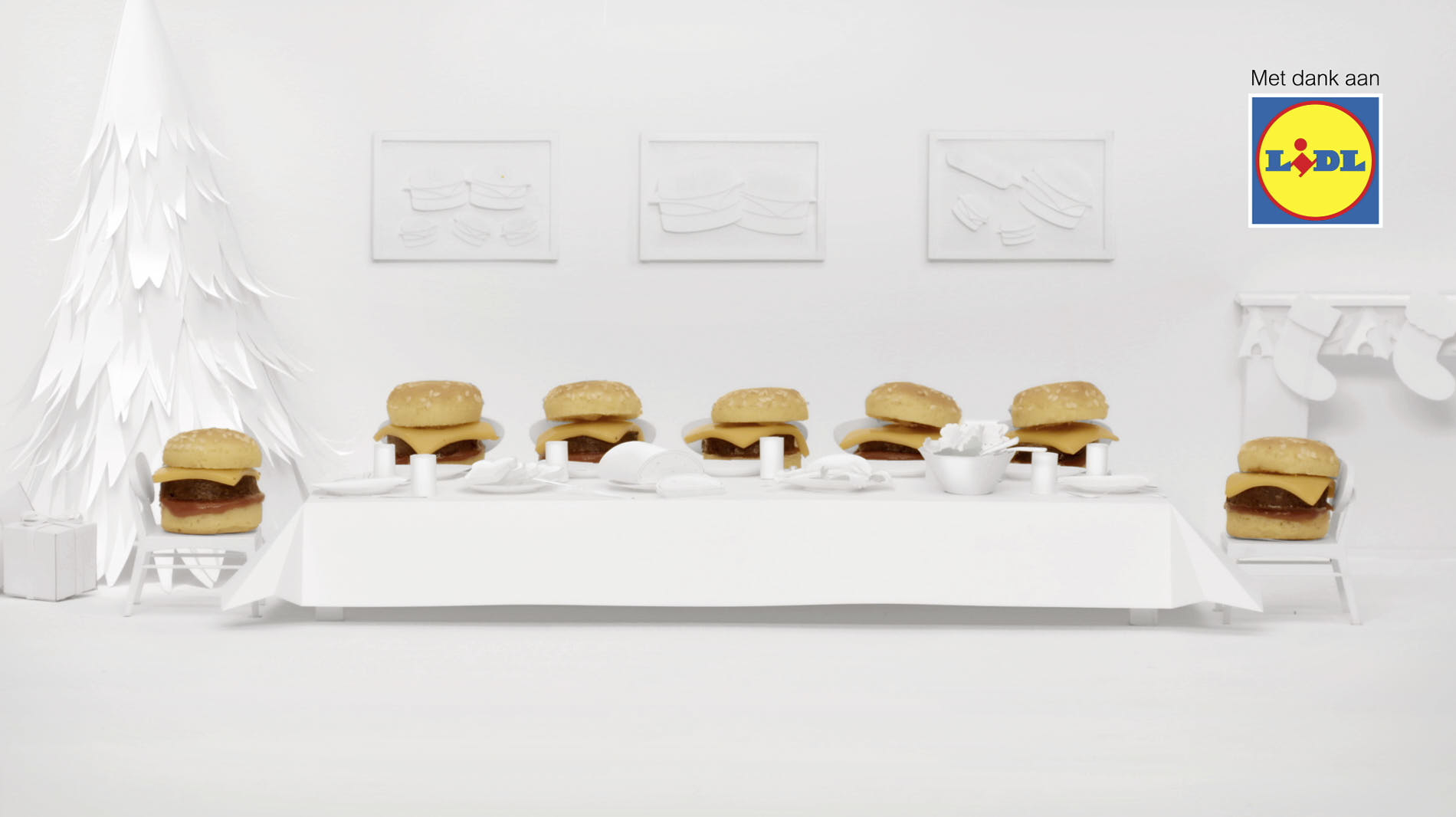 white paper miniature setting of a dinner table and mini-hamburgers sitting on chairs
